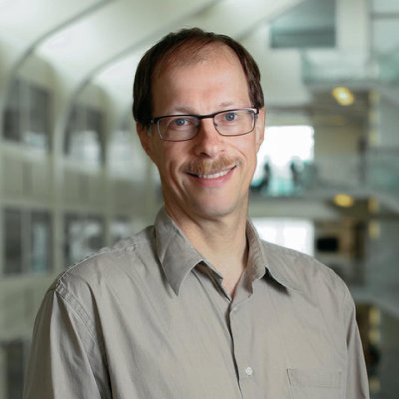 Ralf A. Bundschuh wearing a gray shirt and glasses